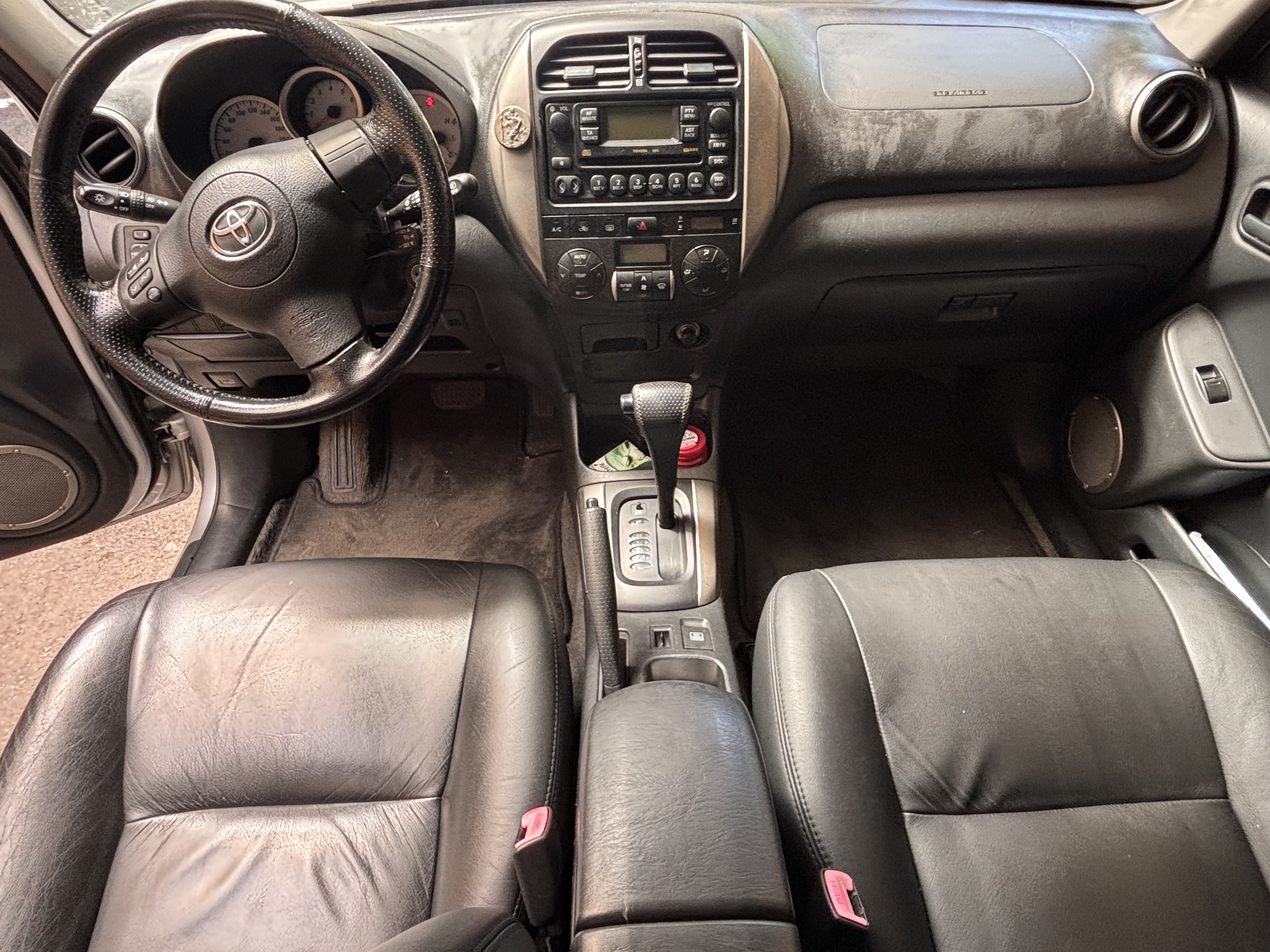 Habitacle Toyota RAV4 avant nettoyage — tableau de bord poussiéreux, tapis sales